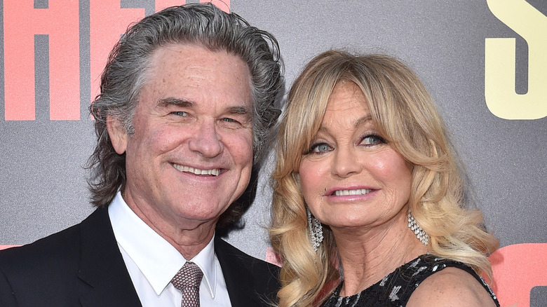 Kurt Russell posing on a red carpet with Goldie Hawn