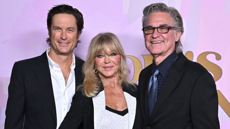 Oliver Hudson posing and smiling with parents Goldie Hawn and Kurt Russell