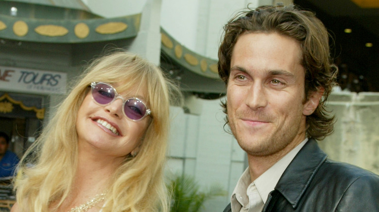 Oliver Hudson and Oliver Hudson smiling while attending a movie premiere