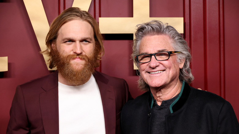 Wyatt Rusell posing on a red carpet with dad Kurt Russell
