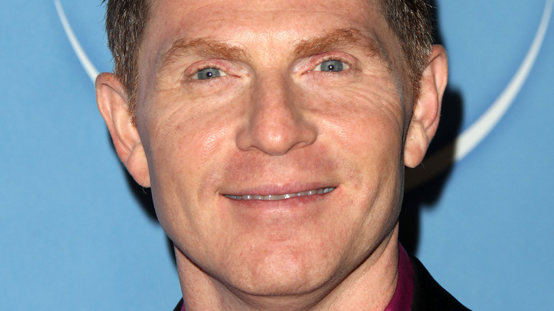 Bobby Flay smiles at an event