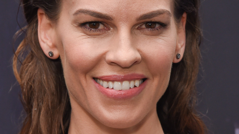 Hilary Swank smiles and wears stud earrings