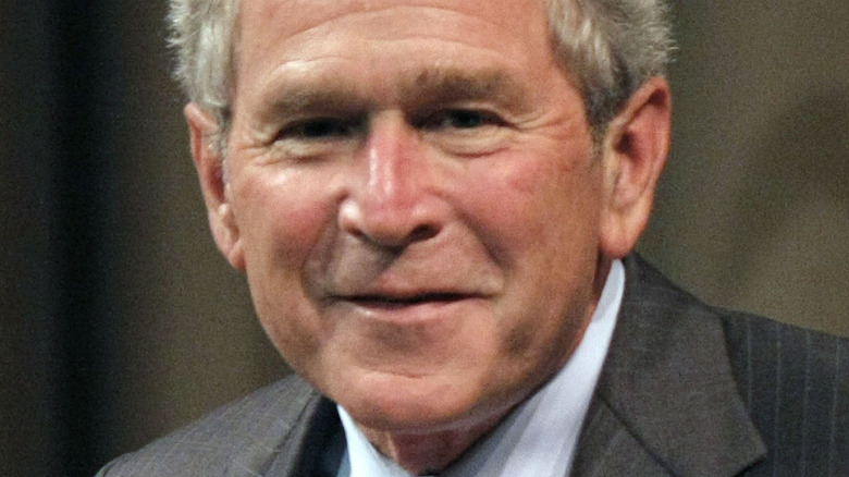 George W Bush smiling and giving speech