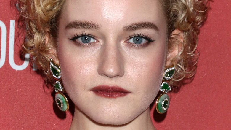 Julia Garner wears green dangle earrings