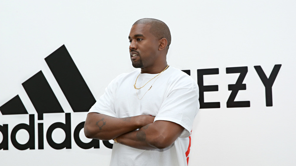 Kanye West poses with crossed arms