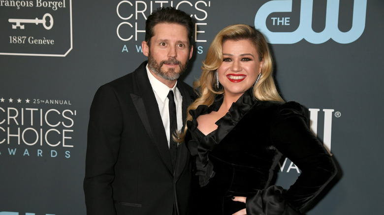 Kelly Clarkson and Brandon Blackstock posing together at an event