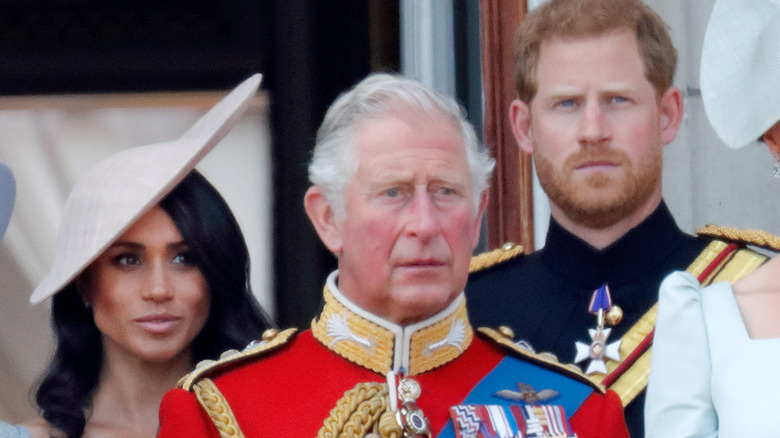 Meghan Markle, Prince Charles, and Prince Harry standing