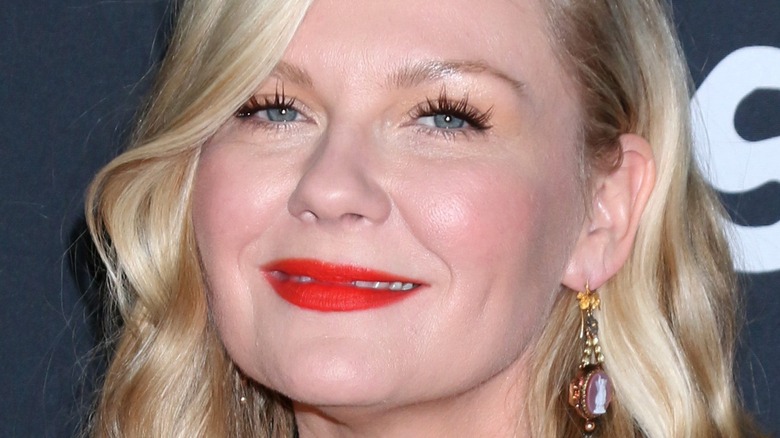 close up of Kirsten Dunst small smile red lipstick