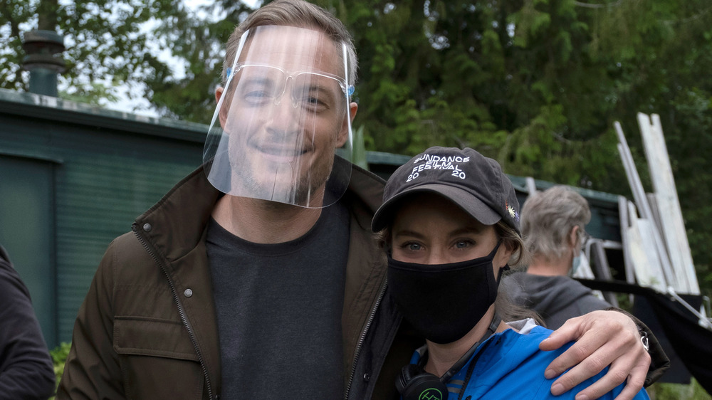 Tahmoh Penikett and Ashley Williams smiling on set