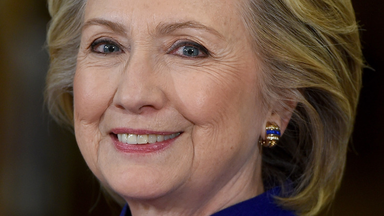 Hillary Clinton smiles in a navy jacket