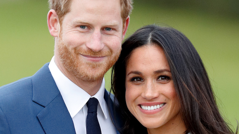 Prince Harry and Meghan Markle smile in formal attire