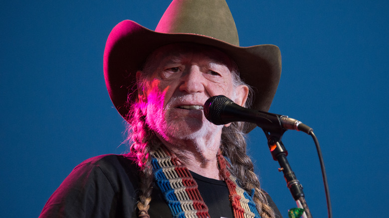 Willie Nelson singing into mic