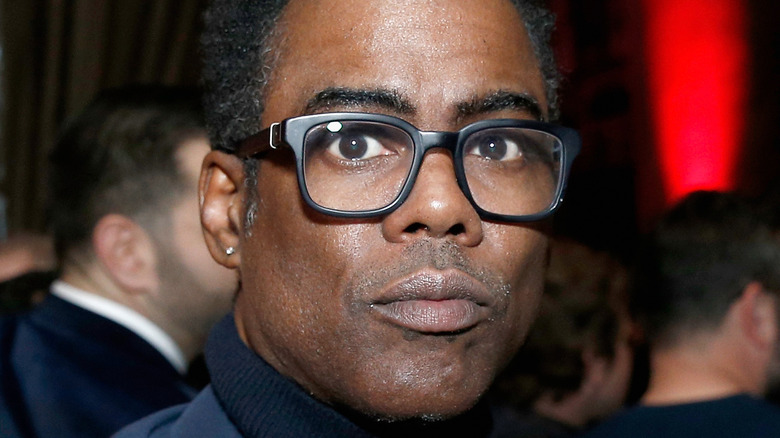 Chris Rock wears glasses and a turtleneck