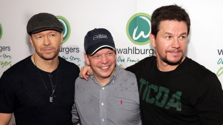 Donnie, Paul, and Mark Wahlberg smiling for a photo