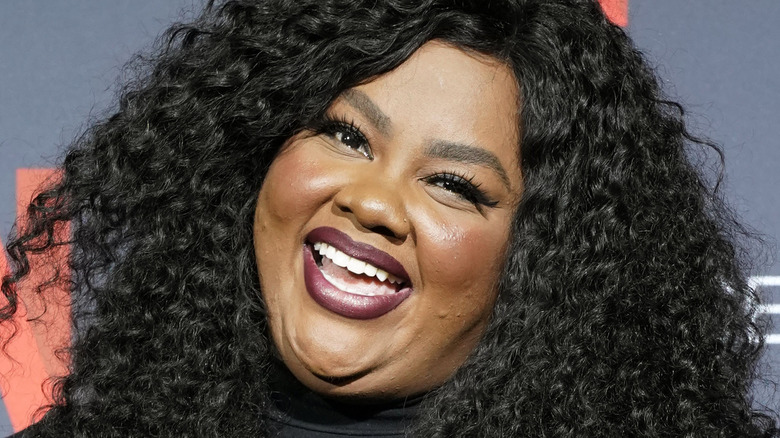 Nicole Byer smiling at a red carpet event