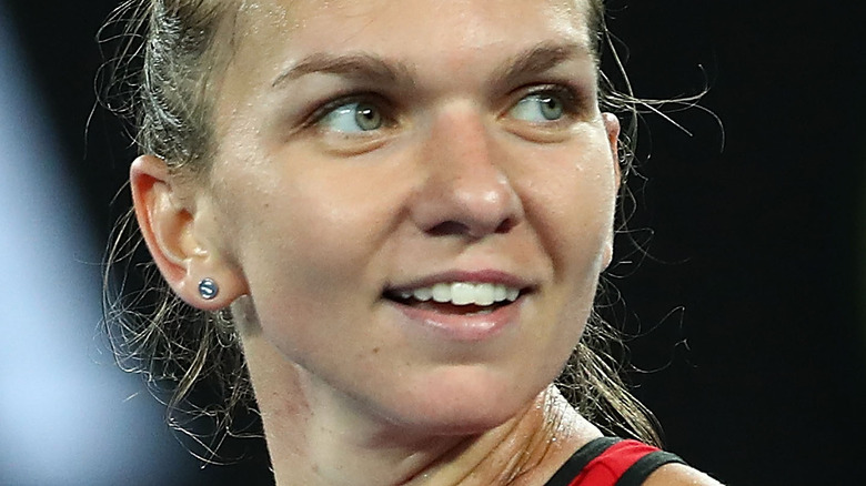 Simona Halep smiling and looking to the side while playing tennis