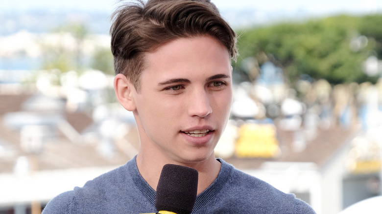 Tanner Buchanan, talking into a microphone, with a look on his face that he just realized something, in an outside interview in 2019