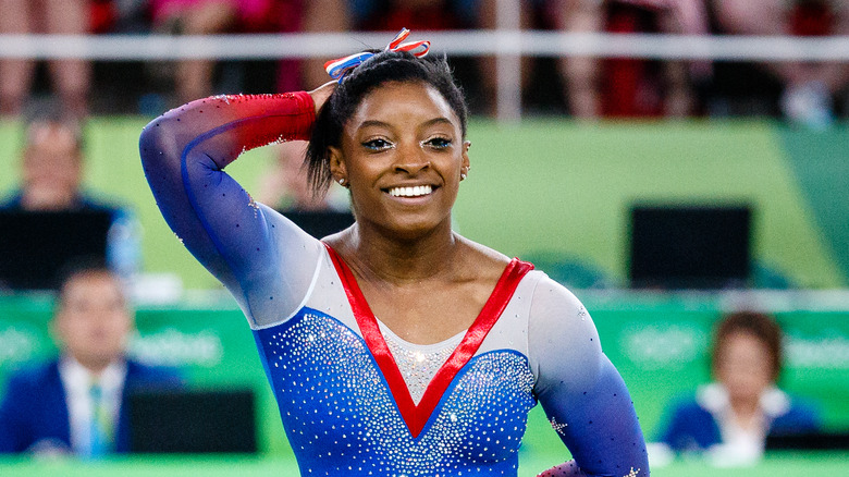 Simone Biles holds her hair