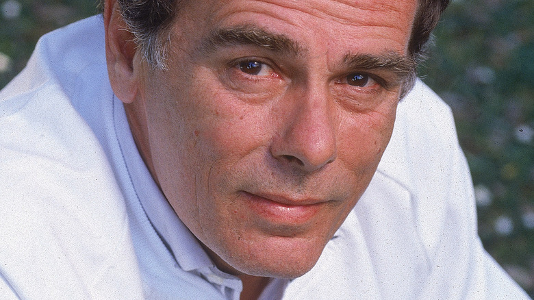 Dean Stockwell crouching outdoors