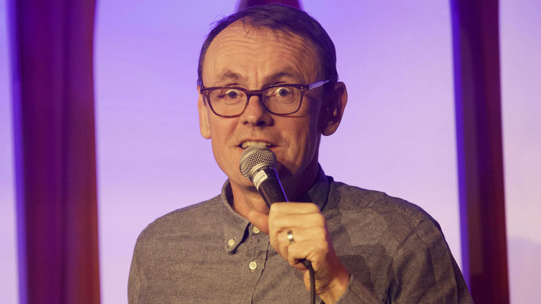 Sean Lock speaks into a microphone
