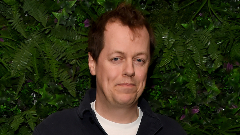 Tom Parker Bowles short brown hair standing by plants