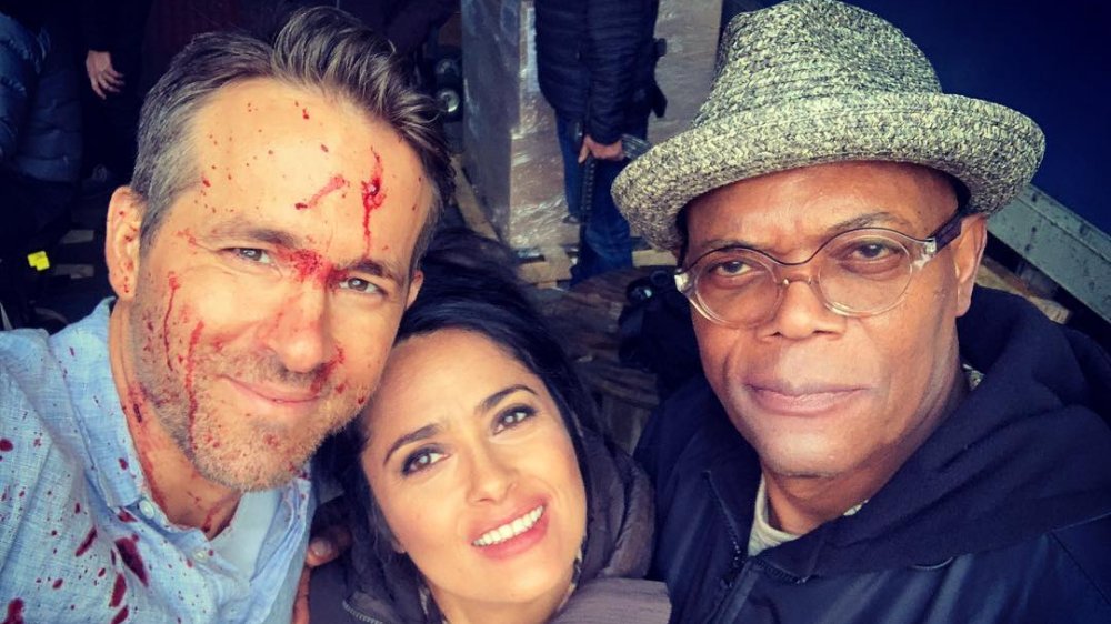 A blood-spattered Ryan Reynolds, Salma Hayek, Samuel L. Jackson posing for a selfie on Instagram