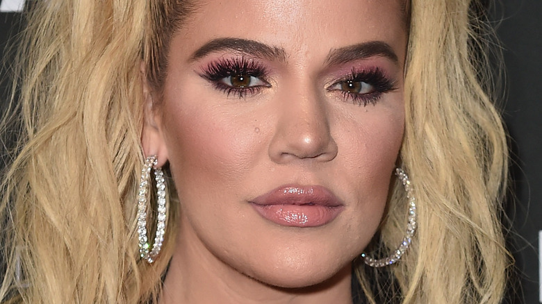 Khloe Kardashian poses with hoop earrings.