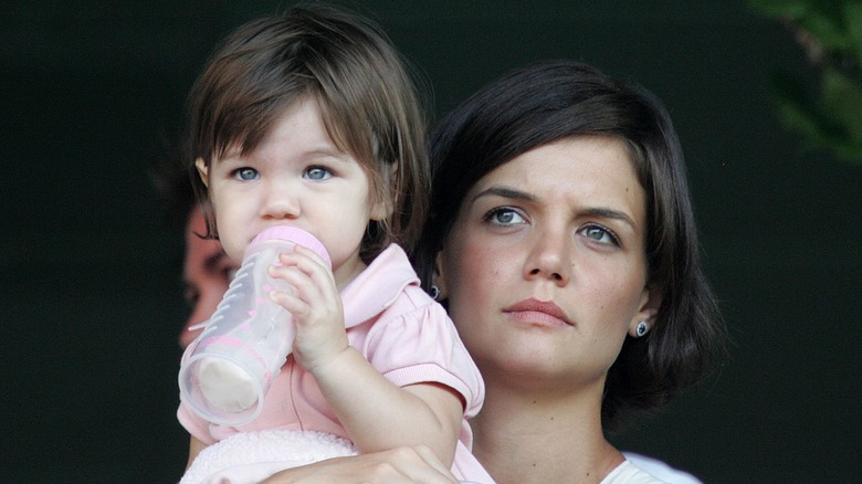 Katie Holmes holding Suri Cruise drinking milk