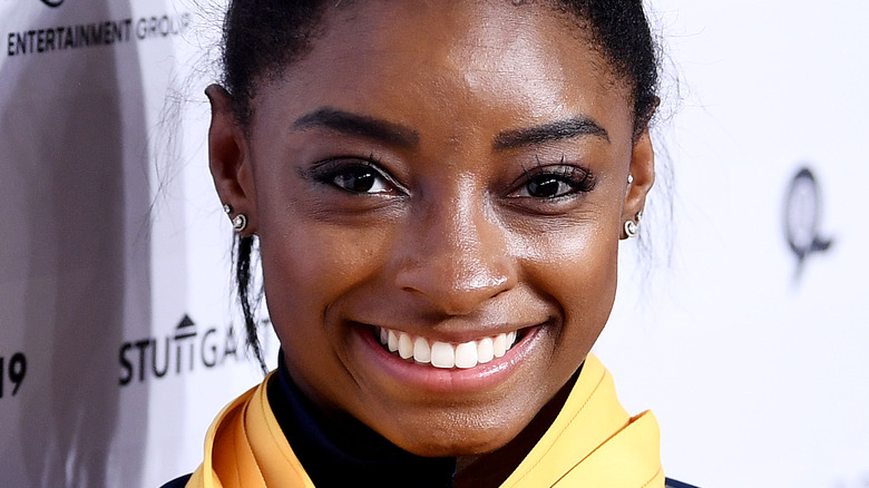 Simone Biles smiles with her medals.