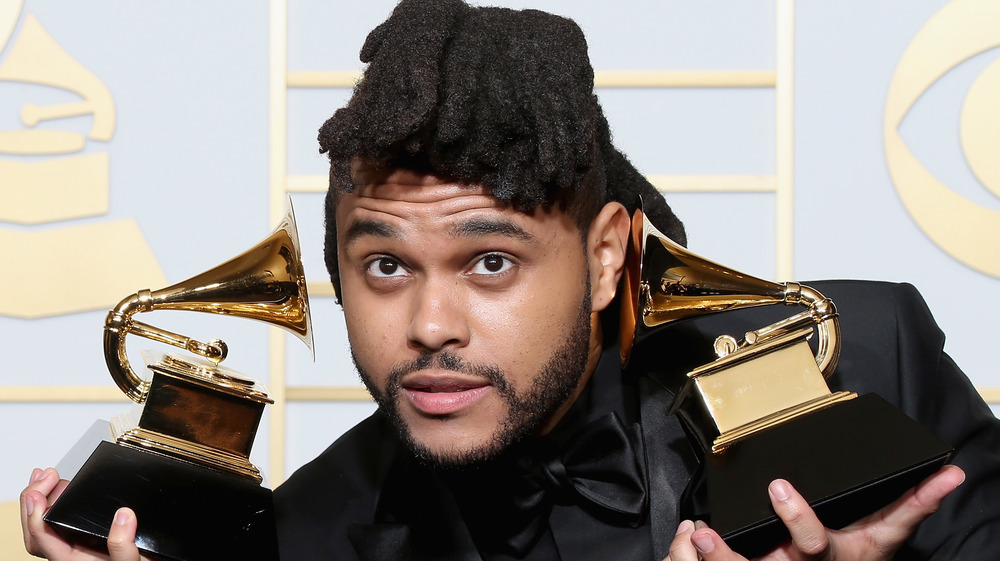 The Weeknd holding his Grammys