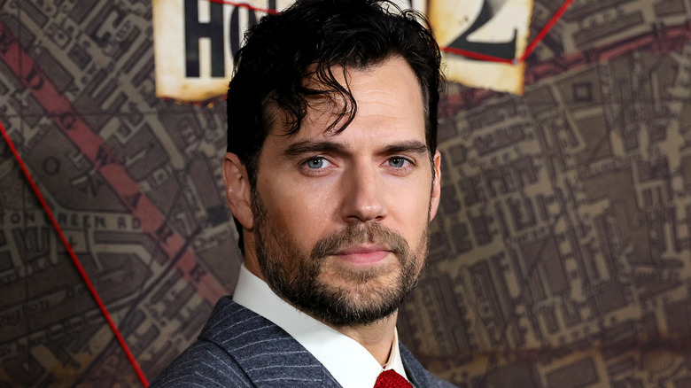 Henry Cavill in a striped suit, posing
