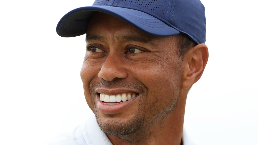 Tiger Woods smiles on a golf course