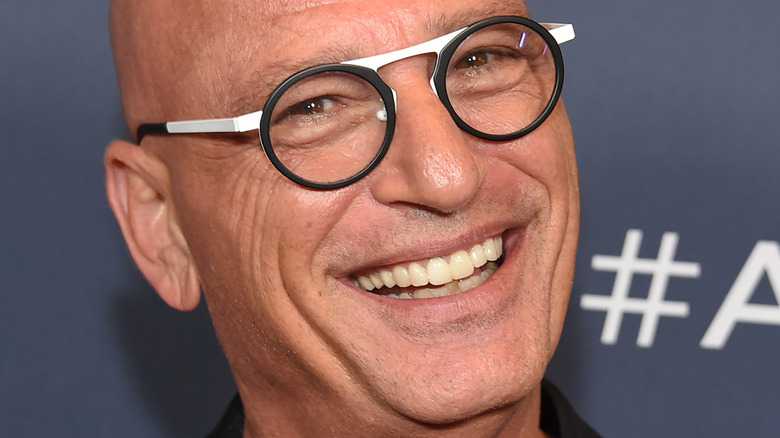 Howie Mandel smiles in modern black-and-white specs