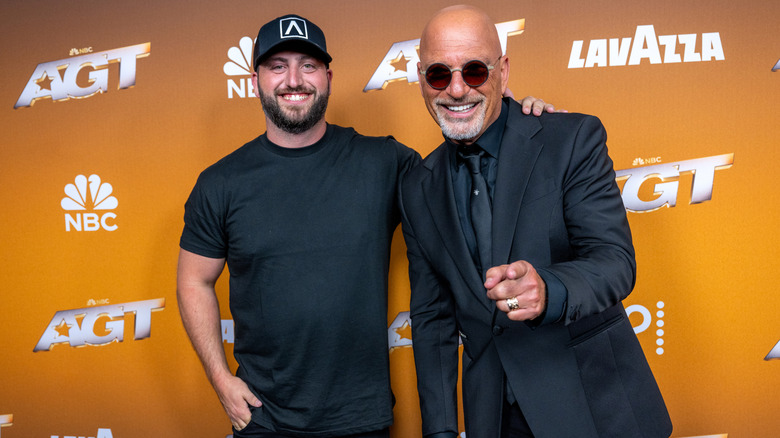 Howie and Alex Mandel pose together on the red carpet a black suit and T-shirt, respectively.