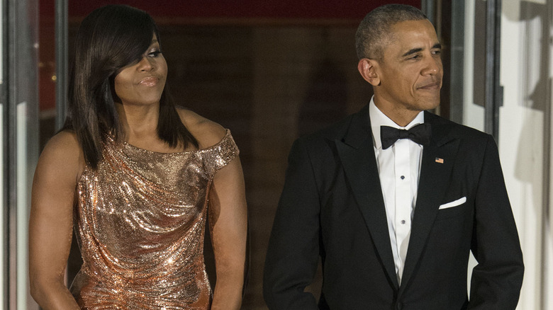 Michelle and Barack Obama, both posing at an event