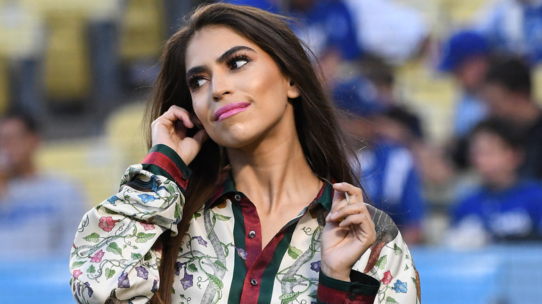 Antonella Barba adjusting an ear monitor while singing the national anthem at a Dodgers game