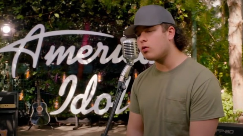 Caleb Kennedy singing in front of the American Idol logo