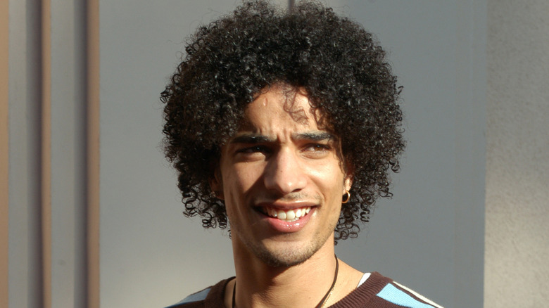 Corey Clark walking outside, wincing against the sun