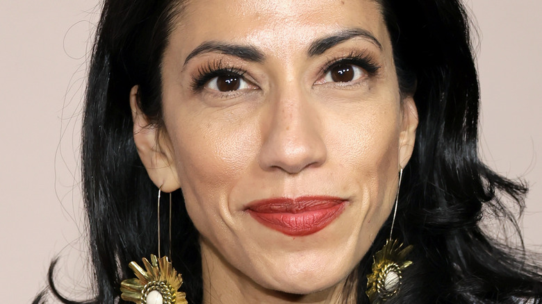 Huma Abedin smiling in red lipstick