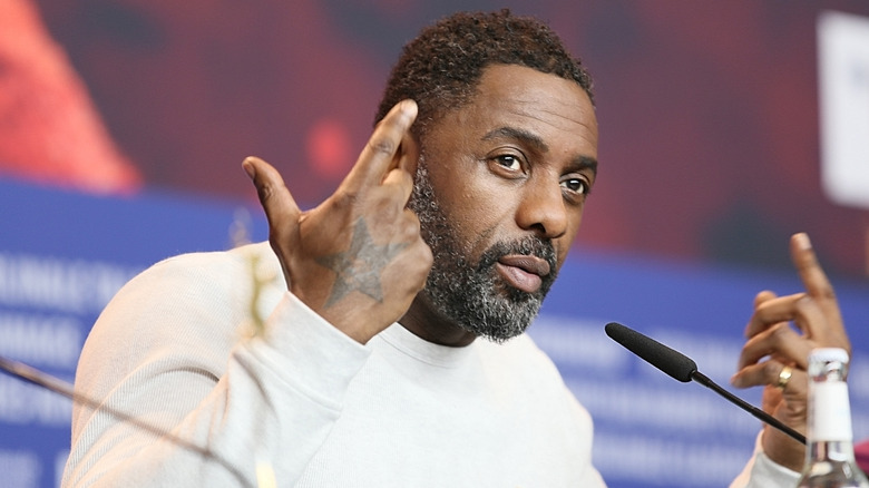 Idris Elba speaks into a mic