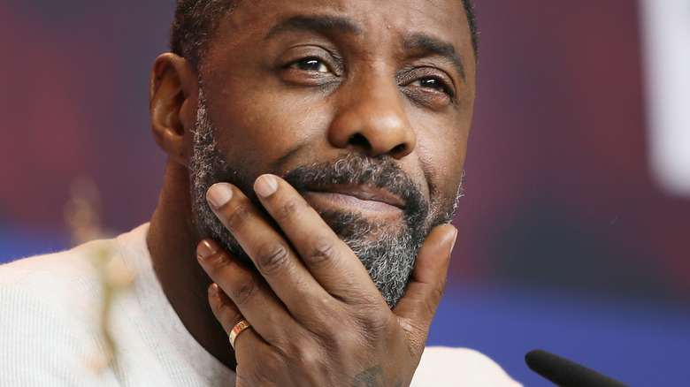 Idris Elba holding his chin 