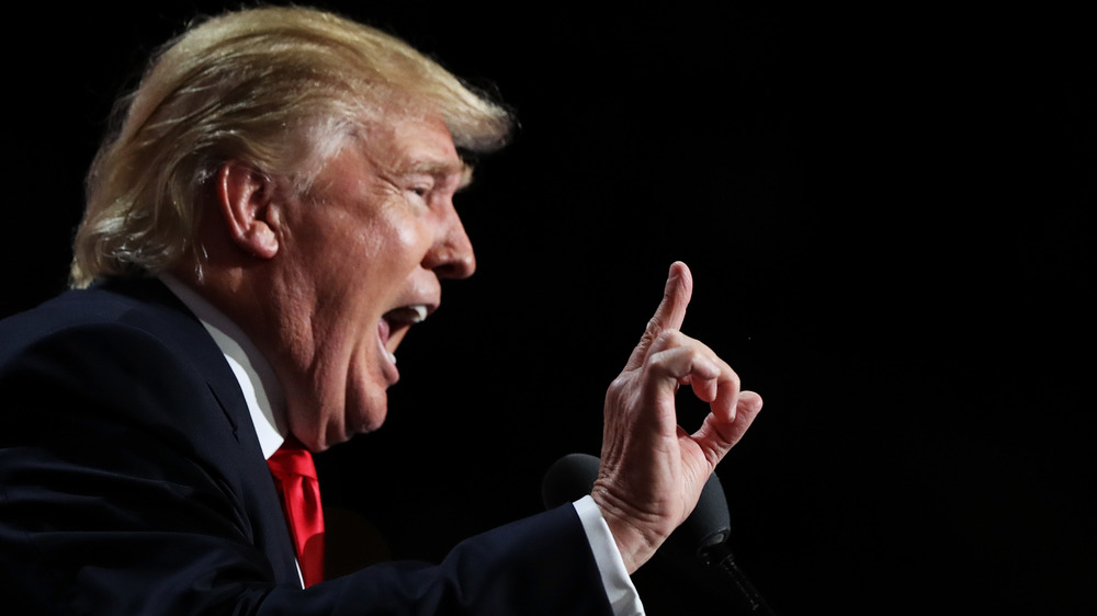 Donald Trump speaking with mouth wide open and finger pointed up