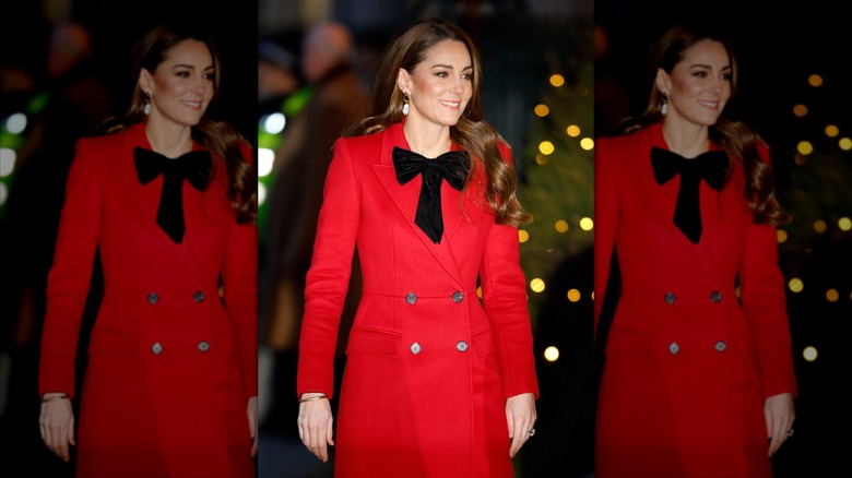 Kate Middleton wears a red coat with a large black bow
