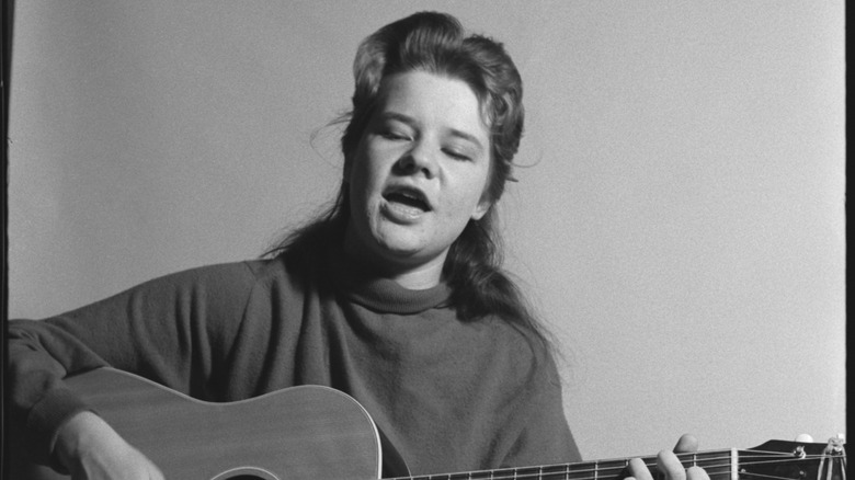 Janis Joplin playing her guitar in 1963