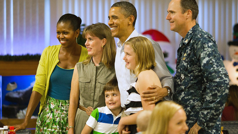 Michelle and Barack Obama posing for photos with military members and their families