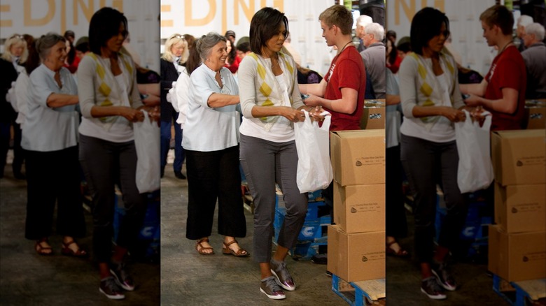 Michelle Obama wearing sneakers while handing out bags of food at a homeless shelter