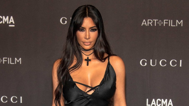 Kim Kardashian posing in a black low cut dress