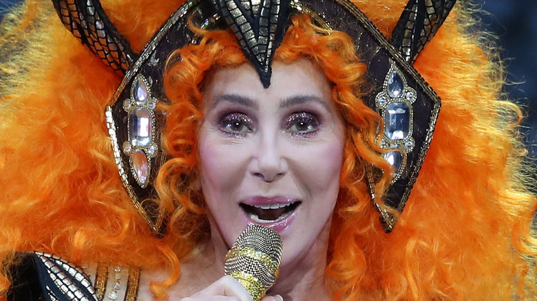 Cher in an orange wig, performing