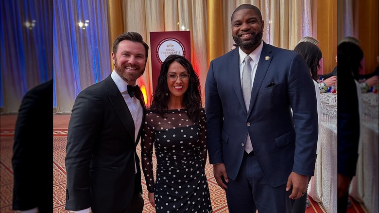 Sporting a polka dot dress, Lauren Boebert is all smiles while standing next to Ed Buckley and Congressman Byron Donalds.