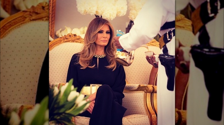 Melania Trump seated wearing black